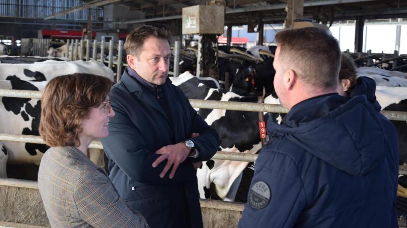 Les commissaires Jessika Roswall et Christophe Hansen écoutent les  explications de l’éleveur laitier Bart Vanderstraeten (de dos) sur le fonctionnement de son exploitation agricole.