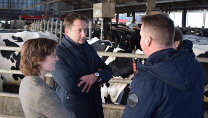 Les commissaires Jessika Roswall et Christophe Hansen écoutent les  explications de l’éleveur laitier Bart Vanderstraeten (de dos) sur le fonctionnement de son exploitation agricole.