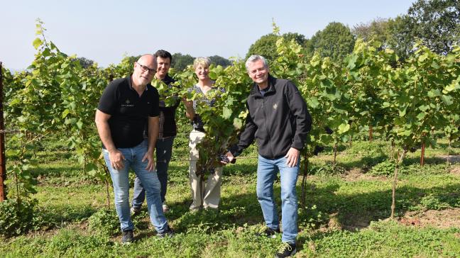 Xavier Bioul (à gauche) et Philippe Minne (à droite) entourent deux membres de leur équipe au coeur du vignoble  implanté en 2022.