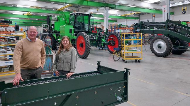 Stefan Top et Majna Seurinck au cœur  de l’usine de Roulers. A l’arrière-plan,  une édition anniversaire de  l’arracheuse Puma.